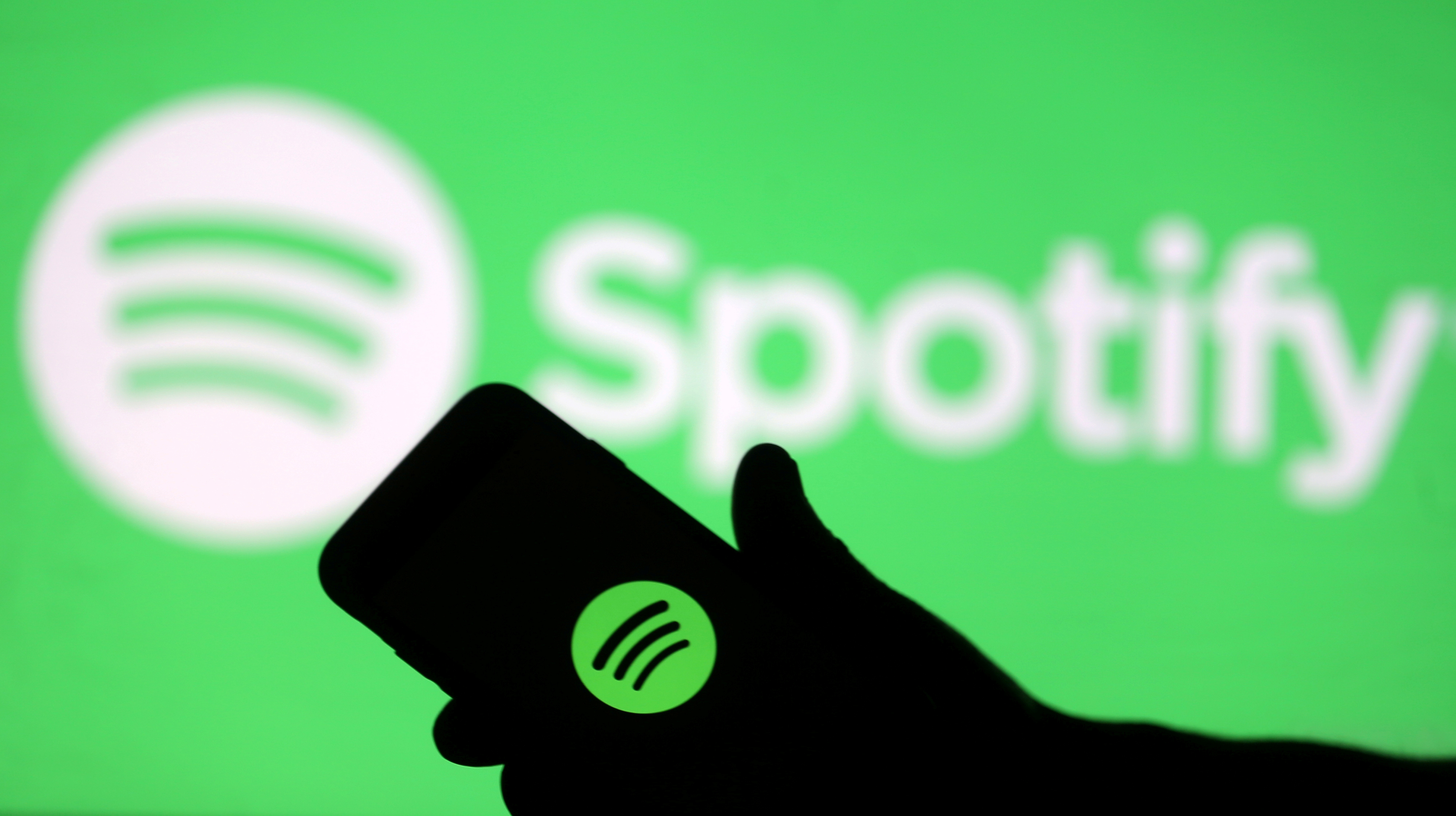 FILE PHOTO: A smartphone is seen in front of a screen projection of Spotify logo, in this picture illustration taken April 1, 2018. REUTERS/Dado Ruvic/Illustration/File Photo  GLOBAL BUSINESS WEEK AHEAD